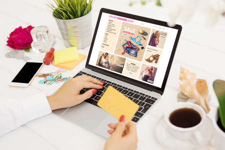 Woman with credit card buying new clothes onlineの写真素材
