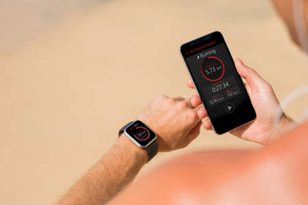 Man using wearable tech during fitness workoutの写真素材