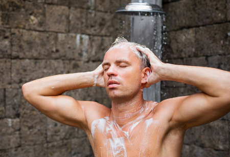 Man washing head in showerの写真素材