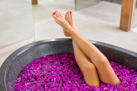 Beautiful woman's legs in flower bathの写真素材