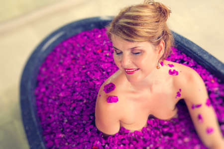 Stress free woman relaxing in romantic flower bathの写真素材