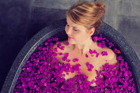Woman in hot tub with purple flowersの写真素材