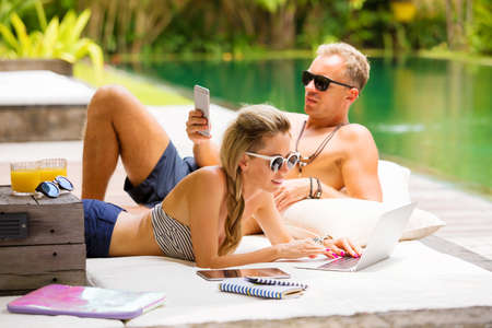 Couple relaxing in hot summer day and using techの写真素材