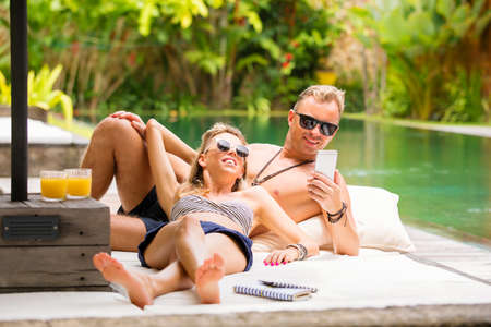 Couple chilling out by the pool on vacationの写真素材