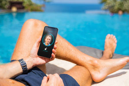 Man unlock mobile phone with facial recognition technologyの写真素材