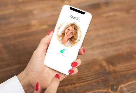 Woman using mobile phone's facial recognition technologyの写真素材