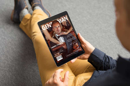 Man reading magazine on tabletの写真素材