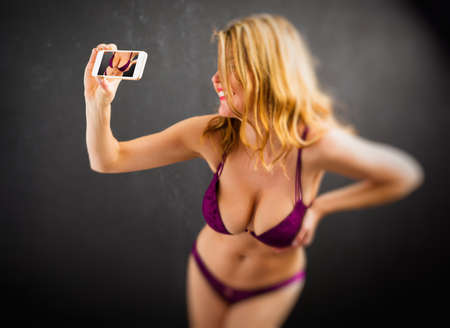 Woman taking sexy selfie photo in underwearの写真素材