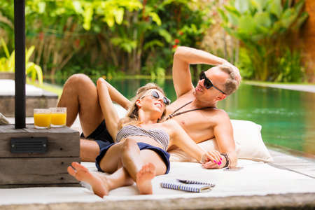 Couple relaxing by the poolの写真素材
