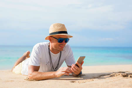 Man with mobile phone on the beachの写真素材