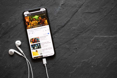 Riga, Latvia - March 25, 2018: iPhone X playing popular song Despacito on YouTube video player.のeditorial素材