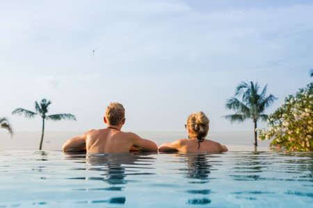 Couple in infinity pool looking at horizonの写真素材