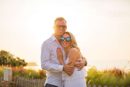 Happy smiling couple at sunsetの写真素材