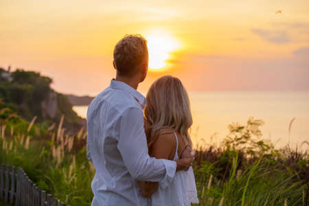 Romantic couple looking at sunsetの写真素材