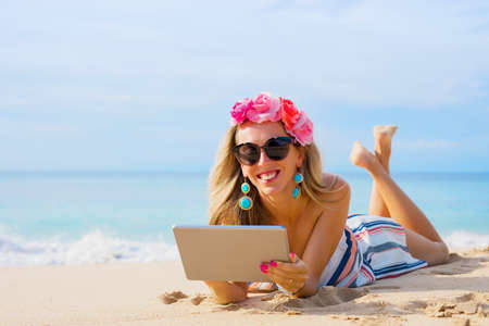 Young woman using tablet on the beachの写真素材