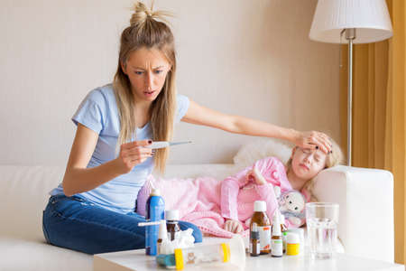 Mother checking temperature of her sick childの写真素材