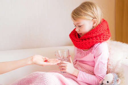 Young girl taking medicine pillの写真素材