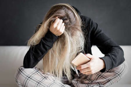 Desperate woman holding mobile phoneの写真素材