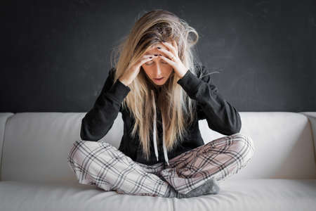 Sad woman in couchの写真素材