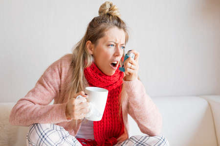 Woman with throat aerosolの写真素材