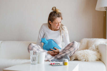 Woman using hot water bottleの写真素材