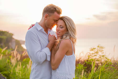 Affectionate couple embrace outdoors at sunsetの写真素材