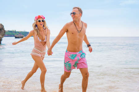 Happy couple running in waterの写真素材