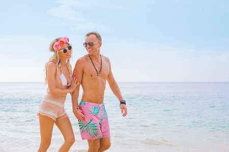 Happy couple walking on the beachの写真素材