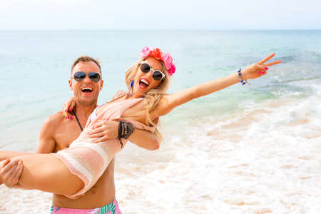 Happy couple laughing on the beachの写真素材