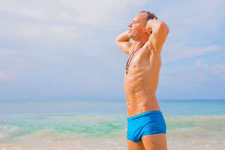 Handsome man enjoying sun on the beachの写真素材