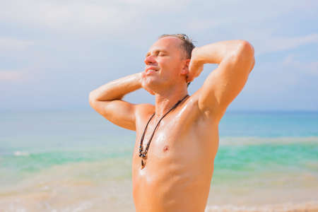 Shirtless man sunbathing on the beachの写真素材