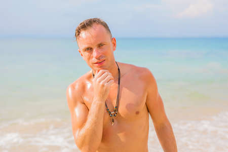 Shirtless man on the beachの写真素材
