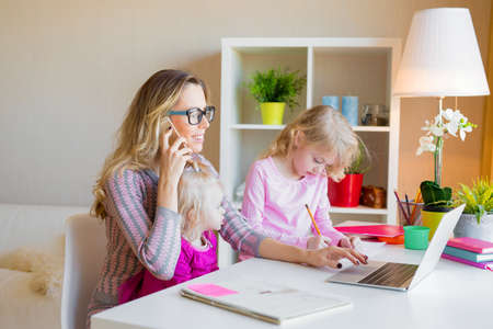 Mom with two daughters working from homeの写真素材
