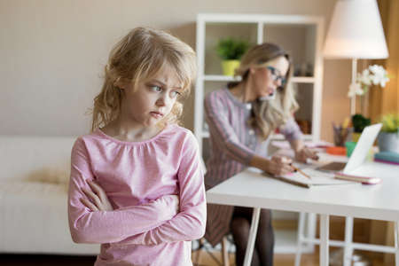 Businesswoman busy working while her child is left without attentionの写真素材
