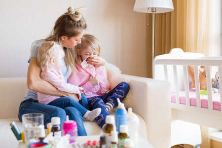 Mom taking care of her sick childrenの写真素材