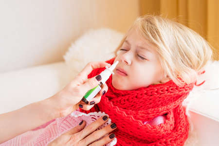 Child with nose sprayの写真素材