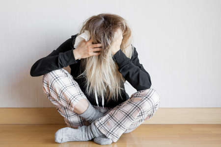 Worried woman sitting on floorの写真素材