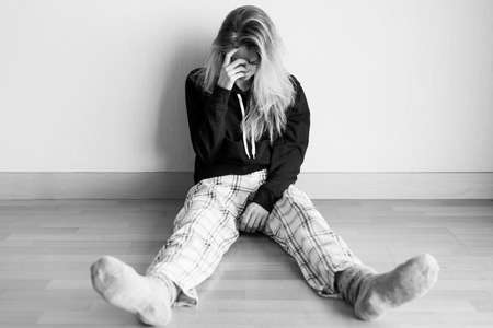 Desperate woman sitting on floorの写真素材