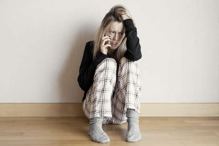 Sad woman talking on phoneの写真素材