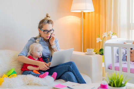 Mom with toddler working on laptopの写真素材