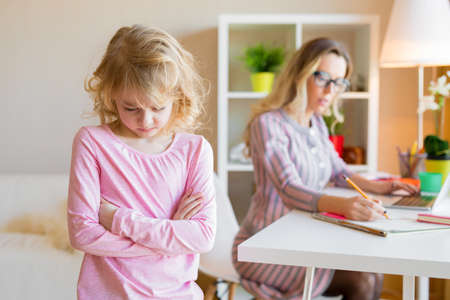Daughter can't get her mom's attentionの写真素材