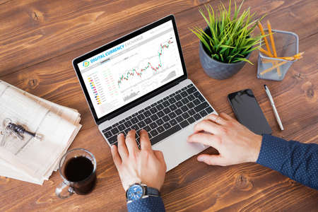 Man trading digital currencies online on laptop computer.の写真素材