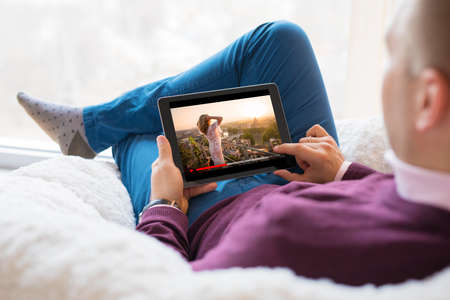 Man watching movie on tablet at home.の写真素材