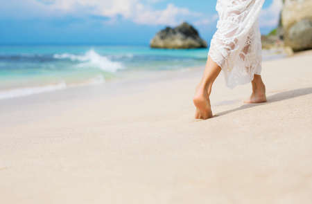 Woman walking in sand on the beachの写真素材