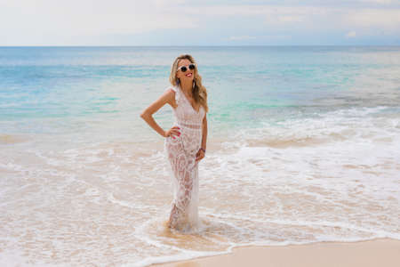 Woman in dress standing in oceanの写真素材