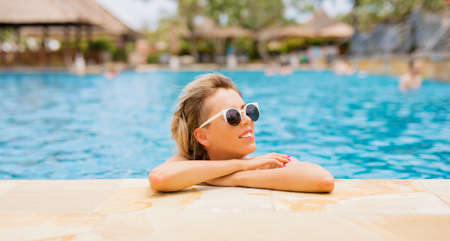 Woman with sunglasses by the poolの写真素材