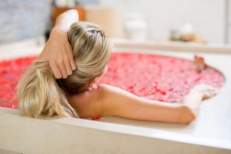 Woman relaxing in bath, view from behindの写真素材