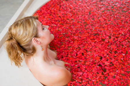Woman in red flower bathの写真素材