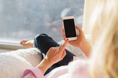 Woman using smartphone at homeの写真素材
