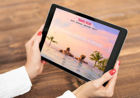 Woman reading travel blog on tabletの写真素材